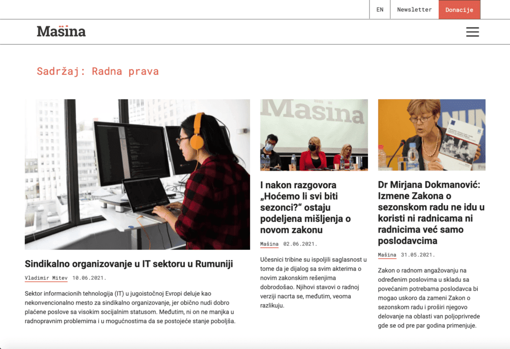 Веб страница под називом Машина садржи три чланка. Главни чланак приказује жену са слушалицама како користи рачунар у отвореној канцеларији, док два мања чланка истичу уметност, панел дискусију и жену која говори о солидарности испред микрофона.